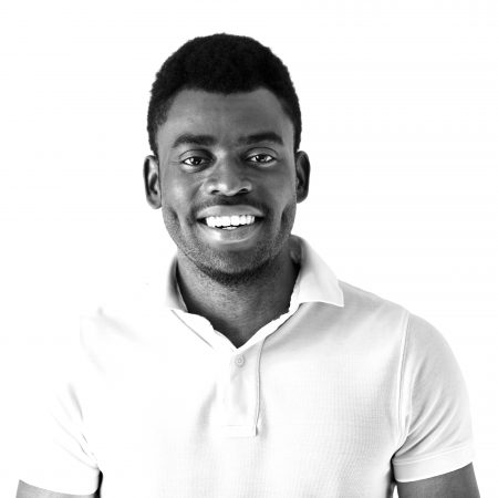 Cropped Shot Of Smiling Handsome Young Casually Dressed African Cropped shot of smiling handsome young casually dressed African man model in white polo shirt smiling showing his teeth against studio background with copy space for your promotional information